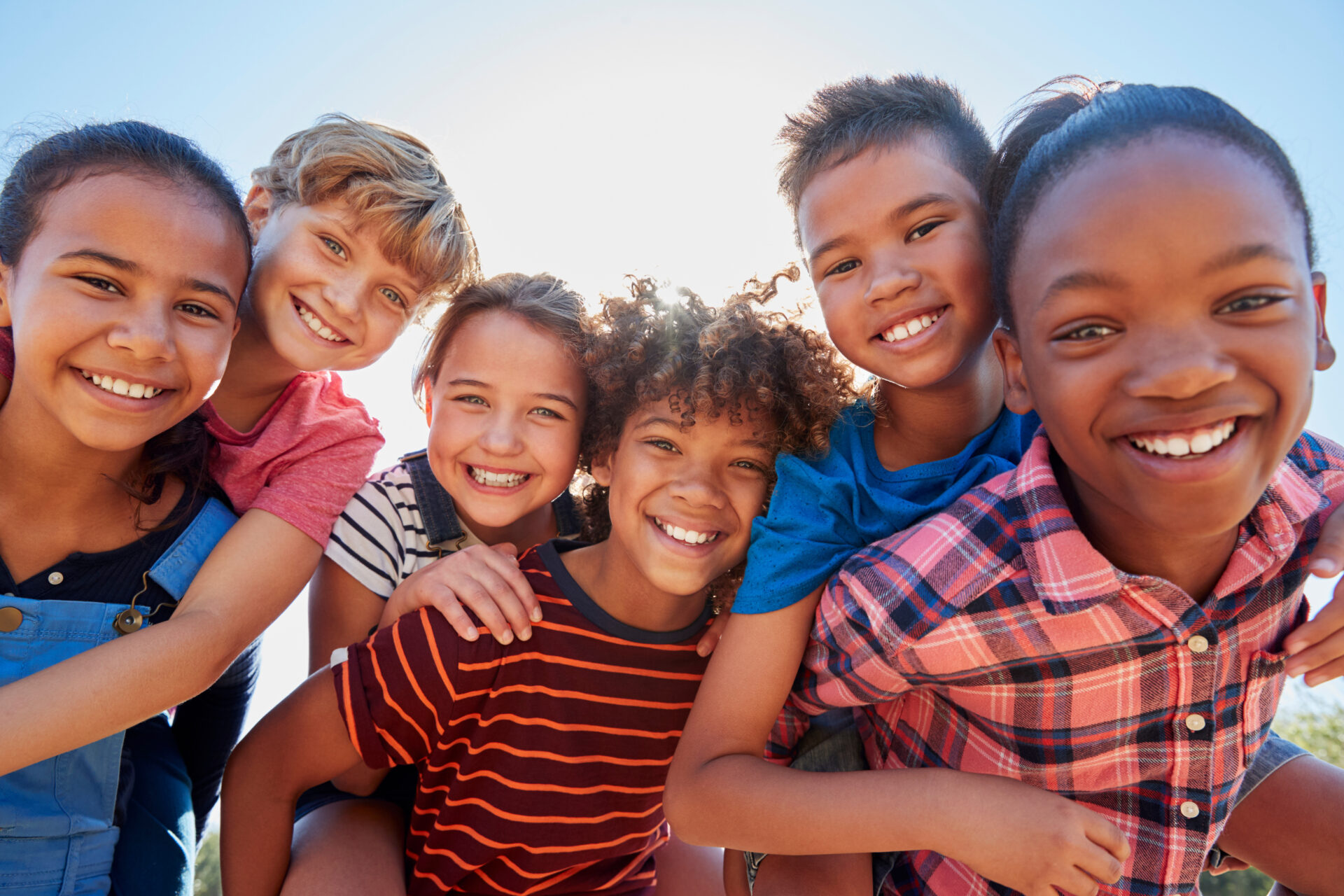 Six pre-teen friends piggybacking in a park, close up portrait Six pre-teen friends piggybacking in a park, close up portrait