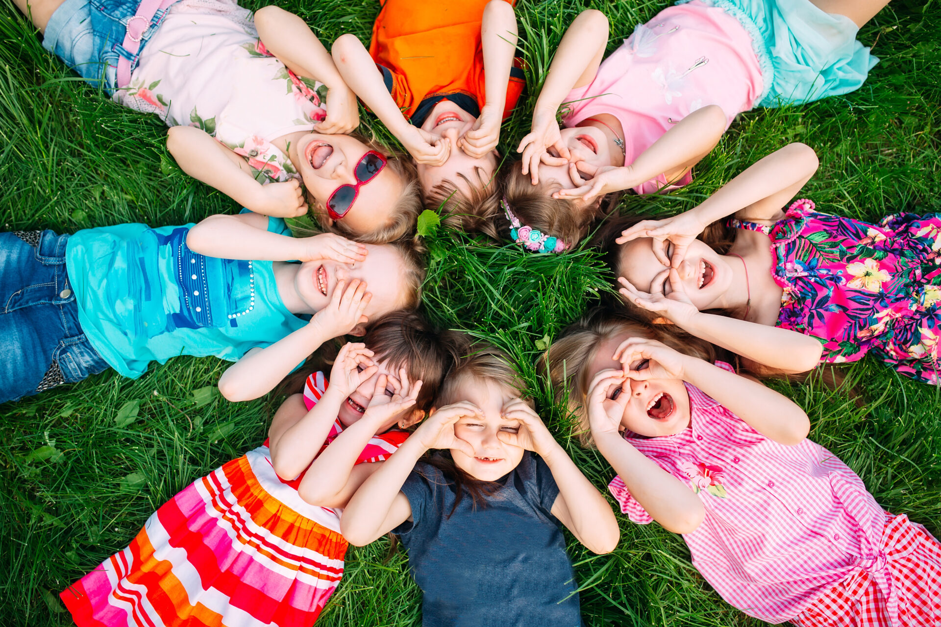 A group of children lying on the green grass in the Park. The in A group of children lying on the green grass in the Park.