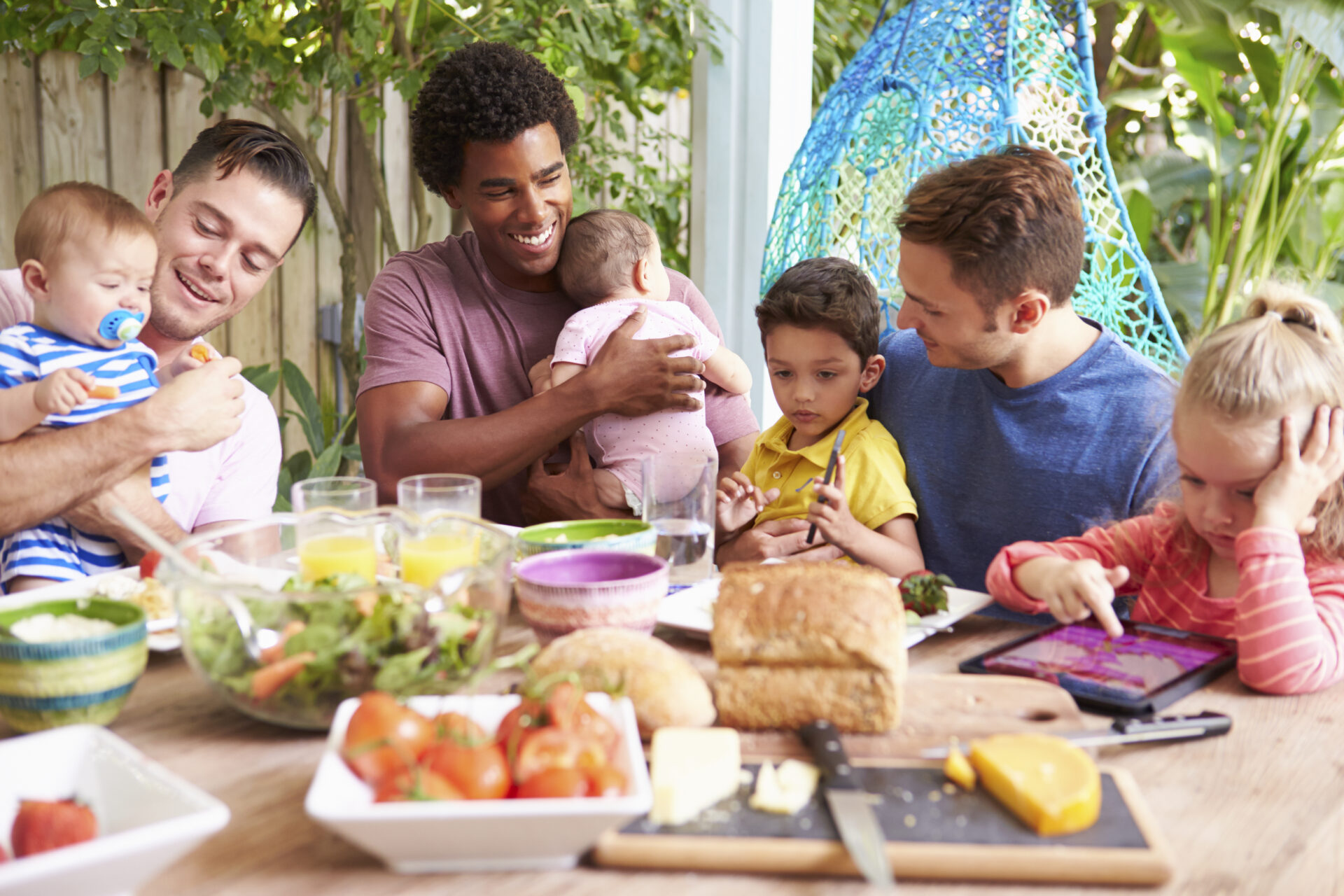 Group Of Fathers With Children Enjoying Outdoor Meal At Home Group Of Fathers With Children Enjoying Outdoor Meal At Home